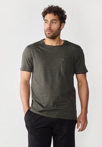 Dark green short-sleeve T-shirt made of soft fabric, featuring a round neckline and a chest pocket. Casual design with relaxed fit.