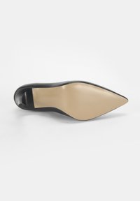Schwarzer High-Heel-Schuh mit spitzer Zehe und einem glatten Lederoberteil. Die Sohle ist beige und bietet einen starken Kontrast zum Schwarz.