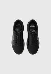 Adidași negri cu un superior din piele netedă și sintetic, având vârf rotund, șireturi plate și detalii cu logo pe limbă și pe laterale.