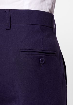 Navy blue trousers made of woven fabric, featuring a flat front pocket with a purple button and belt loops. Smooth texture and tailored design.