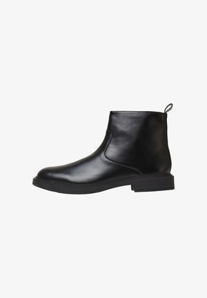 Schwarze Leder-Ankle Boots mit glatter Oberfläche, abgerundeter Spitze, elastischen Seiteneinsatz und einer Zuglasche hinten für ein einfaches Anziehen, ausgestattet mit einer niedrigen Gummisohle.