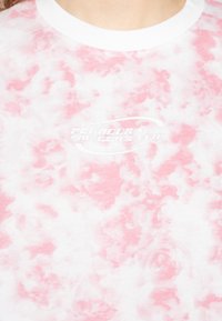 T-shirt de manga curta em padrão tie-dye branco e rosa claro com decote redondo. Apresenta "PEGA DOR BAD GIRLS CLUB" impresso em branco.