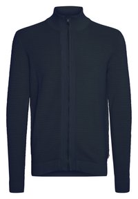 Marineblå jakke med glidelås og ribbestruktur, høy krage og tettsittende mansjetter. Har en sentral glidelås og et rent, minimalistisk design.
