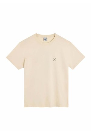 T-shirt beige à manches courtes et col rond avec un petit texte noir disposé verticalement sur le côté gauche de la poitrine indiquant "POULLIN".