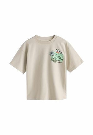 Jasnobeżowy T-shirt z krótkim rękawem z małą, kolorową grafiką „Good Vibes Studio” przedstawiającą kreskówkowe oczy i abstrakcyjne kształty na lewej piersi.