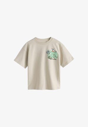 Lysebeige kortærmet T-shirt med en lille farverig "Good Vibes Studio" grafik med tegneserieøjne og abstrakte former på venstre bryst.