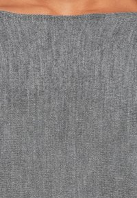 Tecido cinza com um tricot texturizado. O material parece suave e leve, apresentando um padrão uniforme sutil sem acentos distintos.