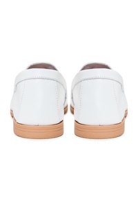 Scarpe in pelle bianca con una superficie liscia, dotate di un tacco basso e suola in gomma marrone chiaro. Il design è minimalista con cuciture sottili.
