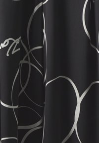 Black fabric featuring a flowing design with interwoven white lines and curves, emphasizing smooth texture and drape.