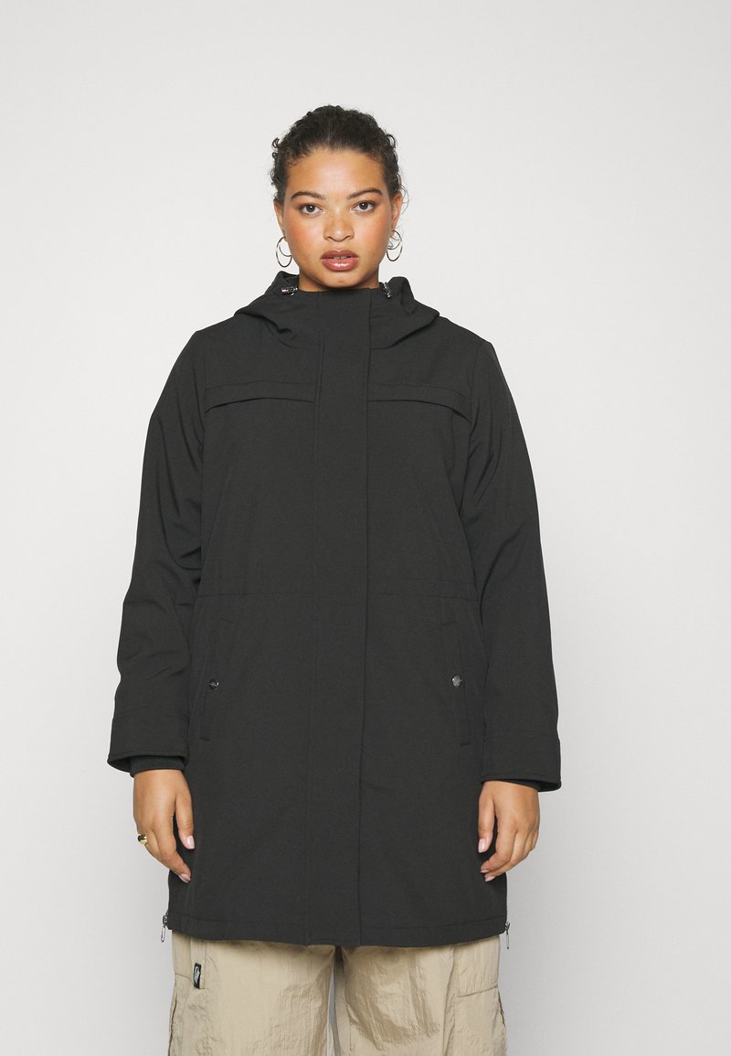 Veste noire à capuche avec fermeture éclair sur le devant, deux poches latérales et coupe droite. Présente une texture textile et un design minimaliste.