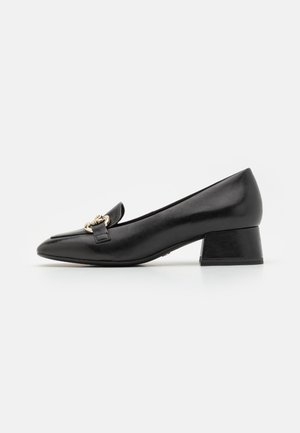 Escarpin en cuir noir avec un bout pointu, un petit talon carré et un détail décoratif en métal doré sur le dessus. Texture lisse.