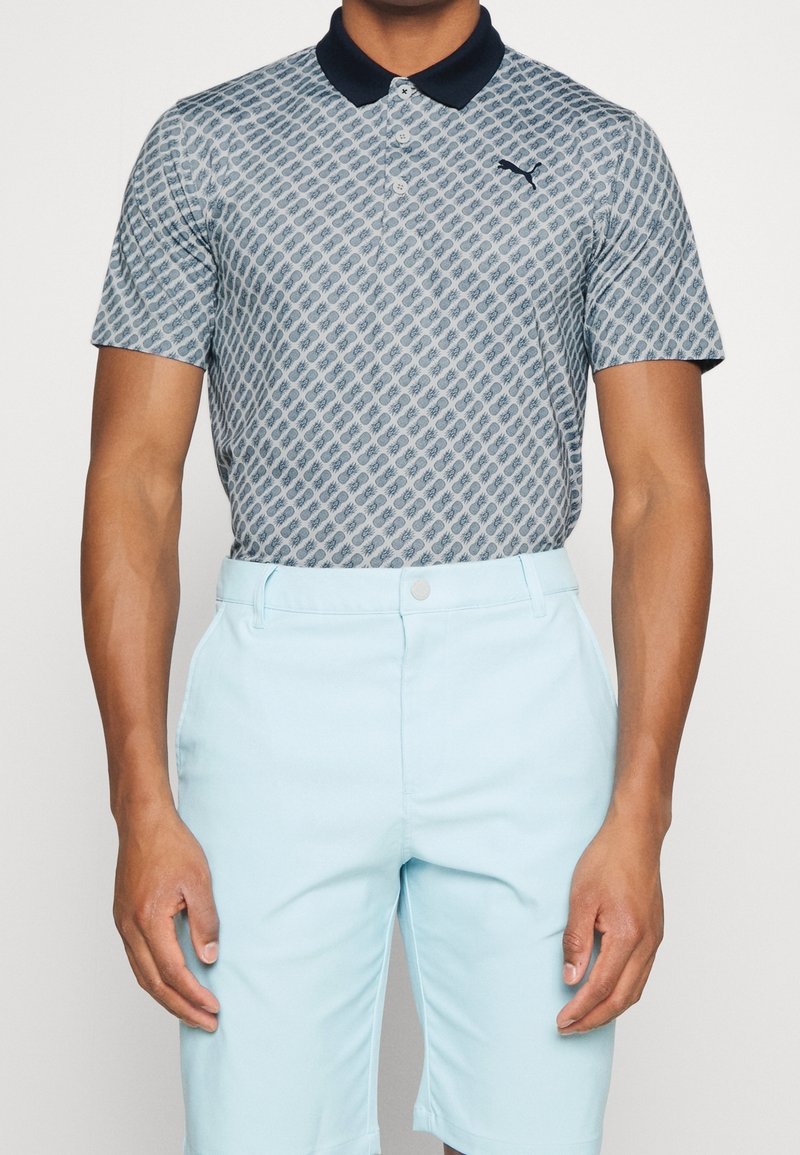 Ljusblå pikétröja med diamantmönster, har en marinblå krage och logotyp. Kombinerad med ljusblå shorts, slät textur, skräddarsydd passform.