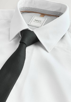 Biela košeľa s textúrovanou čiernou kravatou. Košeľa má hladkú tkaninu a vzorovaný vnútorný golier. Na štítku je nápis "NEXT TAILORING."
