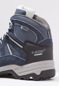 Blaue wasserdichte Wanderschuhe mit einem Obermaterial aus Mesh und Wildleder, Gummisohle, grauen Akzenten und verstärktem Absatz für zusätzlichen Halt.
