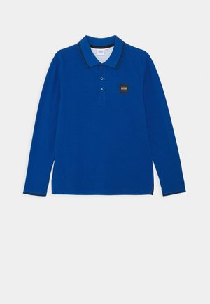 Polo met lange mouwen in koningsblauw met zwarte bies aan kraag en manchetten, drie knopen en een klein zwart logo op de borst.