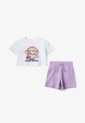 Witte cropped T-shirt met cartoon dieren, regenboog, bloemen en de tekst "ALOHA VACAY" gecombineerd met lichtpaarse short met trekkoord.