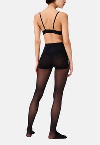 Tights neri opachi con una cintura alta, realizzati in materiale elastico. Texture liscia con una leggera lucentezza, dotati di una cintura comoda.