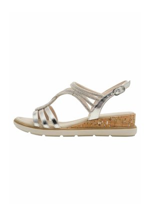 Sandali metallici argento con tacco a zeppa in sughero, dotati di molteplici cinturini e chiusura con fibbia, progettati per comfort e sostegno.