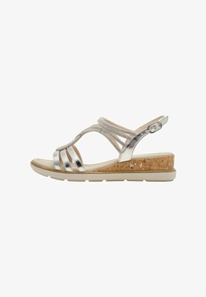 Sandales métalliques argentées avec un talon compensé en liège, dotées de multiples brides et d'une fermeture à boucle, conçues pour le confort et le maintien.