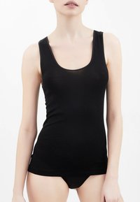 Canotta nera con scollo rotondo e spalline larghe; realizzata in un tessuto liscio e elastico; presenta un design aderente e uno stile minimalista.