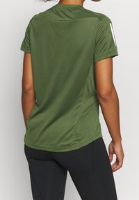Camiseta deportiva color verde oliva con mangas cortas, hecha de material de malla transpirable, con escote redondeado y patrones sutiles de textura.