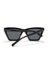 Black cat-eye sunglasses feature dark lenses, a glossy finish, and a geometric design. The temples have branding on the sides.