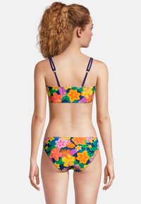 Ensemble de bikini avec un motif floral coloré mettant en avant des fleurs roses, jaunes et vertes sur un fond sombre, avec des bretelles ajustables et une couverture minimale.