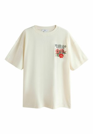 Kremfarvet T-shirt med korte ærmer og rund halsudskæring, med teksten "MAHALO KAILUA-KONA" og tre røde hibiscusblomster på venstre bryst.