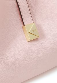 Roze leren handtas met een gestructureerde afwerking en een gouden geometrisch accent met merknaam. Verstelbare riem voor draagopties.