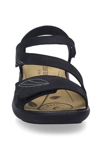 Zwarte sandaal met drie verstelbare banden. Zachte suède bovenkant, gevoerde voetbed met bladpatroon en duurzame rubberen zool.
