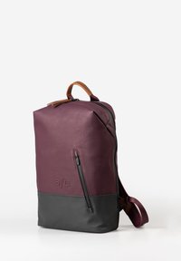 Zaino in pelle viola con finitura opaca, tasca anteriore con zip, pannello inferiore nero e manico marrone, dotato di spallacci regolabili.
