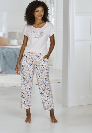 Light pink short-sleeve shirt with "Let your dreams bloom" text; floral-print white pants with orange and blue flowers; relaxed fit.
