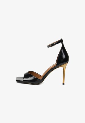 Zwart lakleren sandalen met hoge hak, gouden naaldhak, enkelbandje met gesp en open vierkante neus.