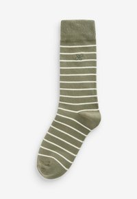 Chaussette en coton vert olive avec des rayures horizontales blanches, bord ribbé et talon renforcé. Présente un petit logo sur le côté.