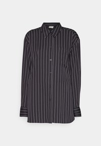 Chemise noire à manches longues boutonnée avec fines rayures blanches verticales et col classique sur un fond clair uni.