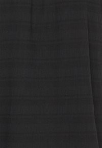 Tissu noir texturé présentant des rayures horizontales subtiles, doux au toucher avec une finition mate, adapté à diverses applications vestimentaires.