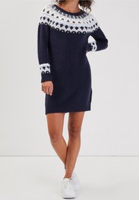 Abito maglione lavorato a maglia di color blu navy con yoke a motivi bianchi, maniche lunghe, polsini e orlo a coste. Tessuto morbido, design fino al ginocchio.