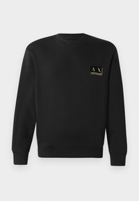 Black long-sleeve crewneck sweatshirt with small beige Armani Exchange logo on left chest.