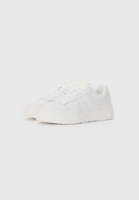 White synthetic sneakers with a textured sole, smooth finish, round toe, and thin laces. Features subtle side accents in a shiny material.