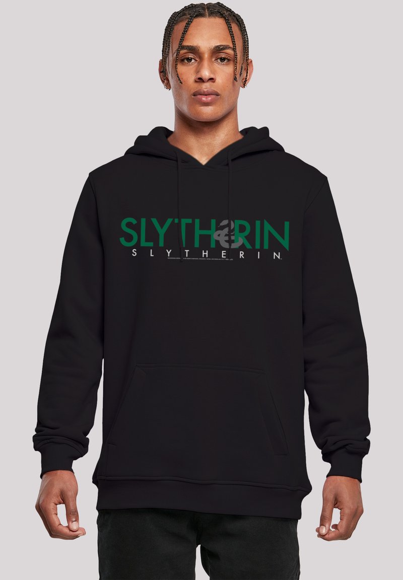 Svart hettegenser med teksten "SLYTHERIN" i grønt og hvitt. Inkluderer en frontlomme og snor. Laget av myk, komfortabelt stoff.