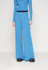 Blue patterned long-sleeve top and wide-leg pants made of soft fabric. The pants feature a black waistband and loose, flowing silhouette.