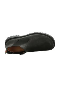 Botín negro de cuero hasta el tobillo con paneles laterales elásticos, punta redondeada y suela texturizada. Presenta una pequeña etiqueta verde y roja en el talón.