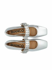 Srebrne syntetyczne buty Mary Jane z kwadratowym noskiem, regulowanym paskiem z metalowymi ćwiekami i wyprofilowaną wkładką. Logo "Bianco" wewnątrz.