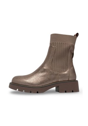 Bottines métalliques en bronze avec des panneaux latéraux élastiques, un tissu texturé et un talon épais. Semelle extérieure en caoutchouc durable avec un contour de semelle contrastant.