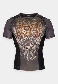 Īsām piedurkņu rashguard, melnā un oranžā krāsā, ar tīģera grafiku, sietu detaļām un pieguļošu dizainu ar noapaļotu kakla izgriezumu.