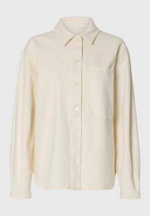 Long-sleeve cream button-up shirt with pointed collar and single chest pocket, made from soft, textured fabric.