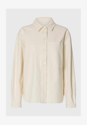 Long-sleeve cream button-up shirt with pointed collar and single chest pocket, made from soft, textured fabric.