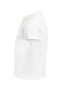 Camiseta de algodón blanca con cuello redondo y mangas cortas. Textura suave, forma ajustada, sin patrones ni acentos visibles. Vista de perfil lateral.