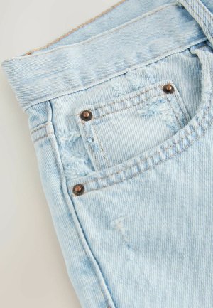 Svijetloplave traper šortse sa istrošenim dizajnom, vidljivim trošenjem i malim džepom s bakrenim zakovicama.