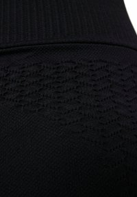 Black fabric with a textured pattern featuring raised lines. The material is smooth with a ribbed waistband at the top.